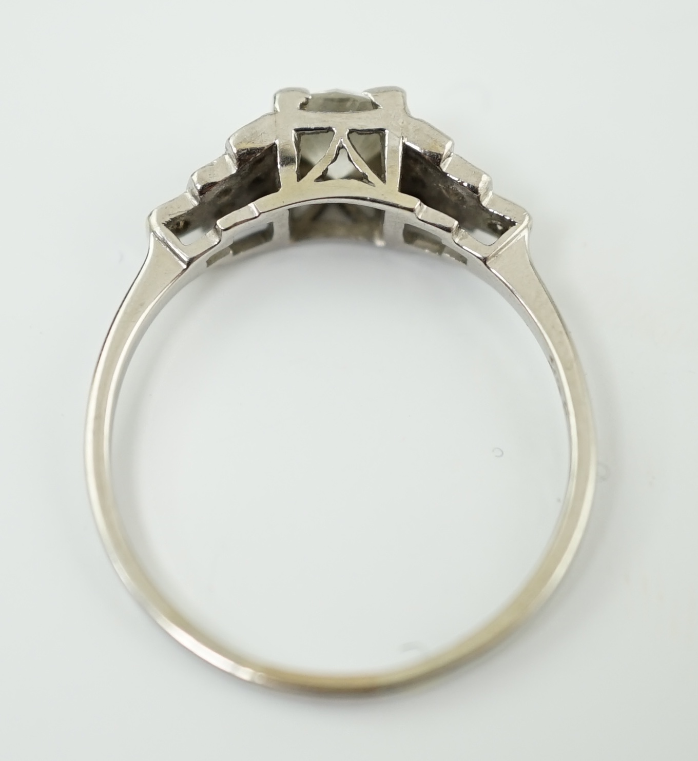 An Art Deco 18ct white gold, platinum and single stone diamond ring, with twelve stone diamond chip set stepped shoulders